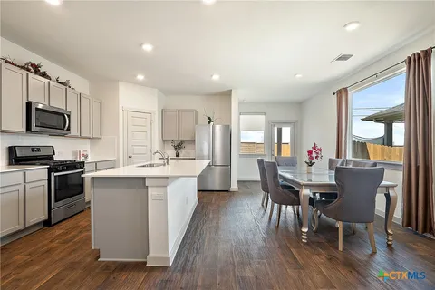 a view of kitchen with sink dining table and chairs