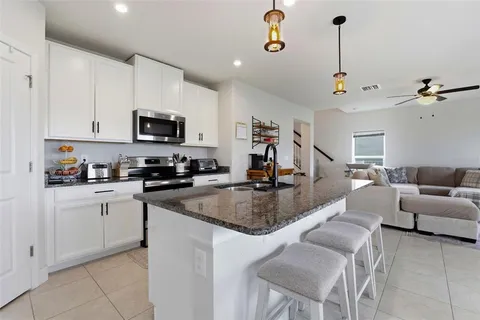 a kitchen with stainless steel appliances granite countertop a sink a stove and a refrigerator