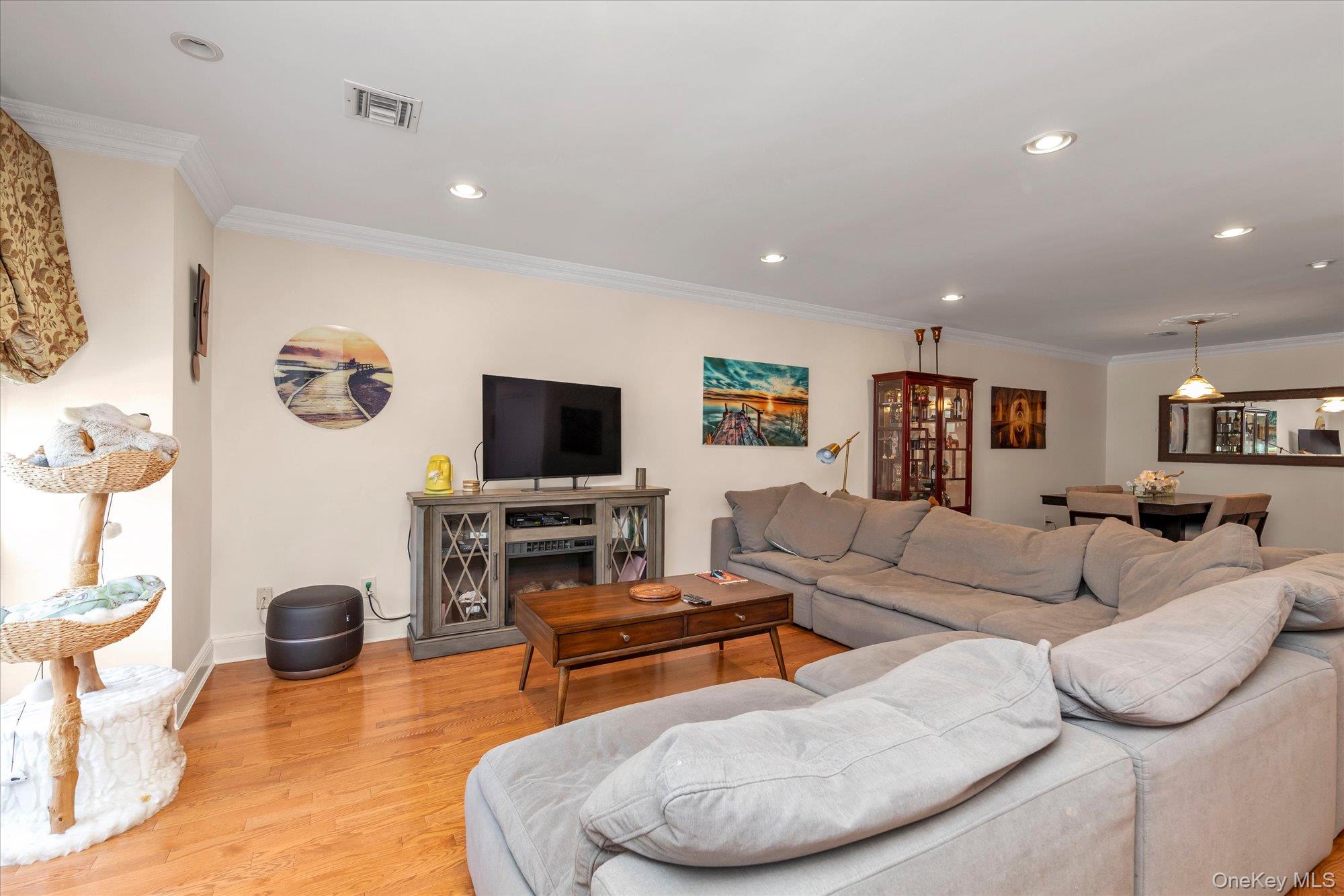 150 I U Willets Road Albertson, NY 11507 - Photo 3 of 21 Open-concept living room featuring hardwood flooring, recessed lighting, and crown molding