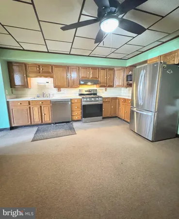 a kitchen with a stove a refrigerator and a fireplace