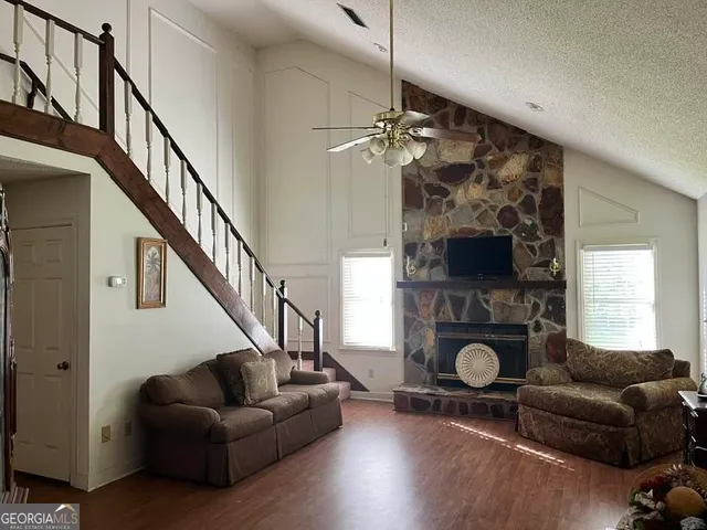 a living room with furniture a flat screen tv and a window