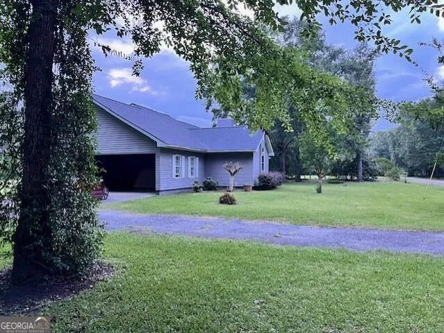 a view of a house with a yard and tree s