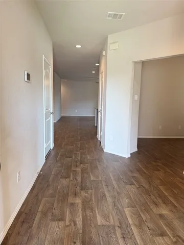 a view of a hallway with wooden floor