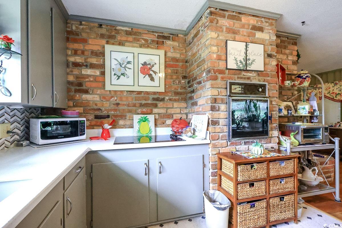 404 13th Avenue South Myrtle Beach, SC 29577 - Photo 5 of 39 Kitchen with black appliances, gray cabinetry, light countertops, backsplash, and a textured ceiling