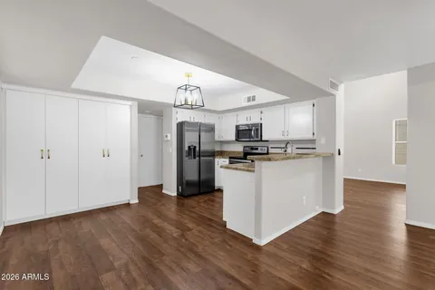 a kitchen with stainless steel appliances a refrigerator and wooden floor
