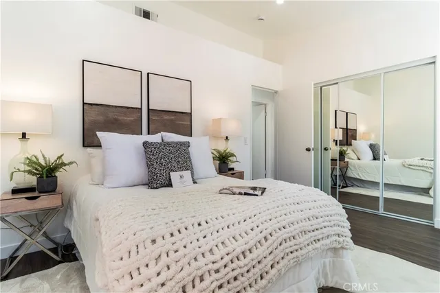 a bedroom with a large bed and a potted plant