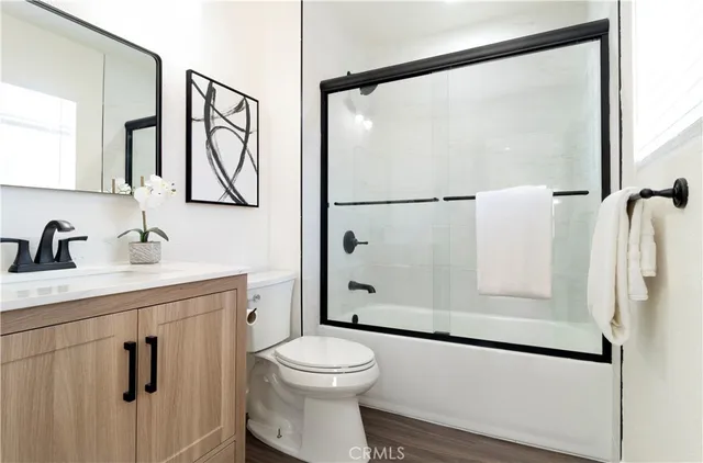 a bathroom with a shower sink vanity mirror and toilet
