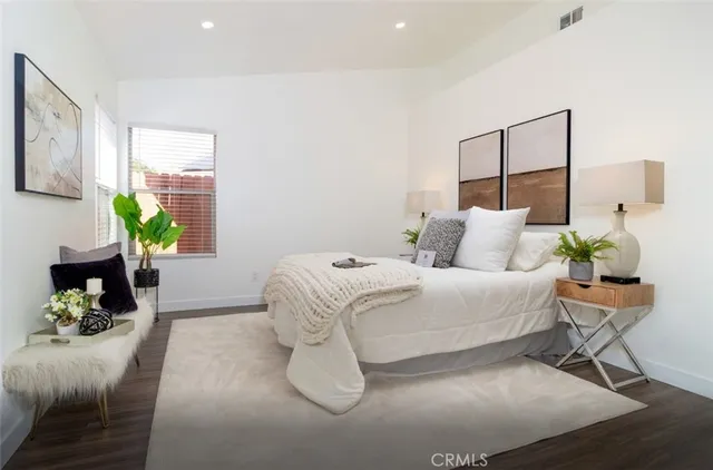 a bedroom with a bed table and chair