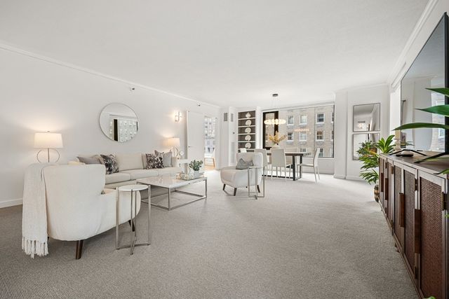 a living room with furniture a rug and white walls