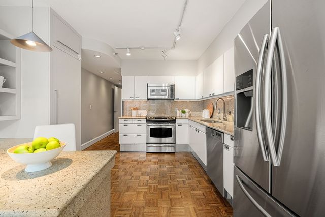a kitchen with stainless steel appliances granite countertop a refrigerator and a stove