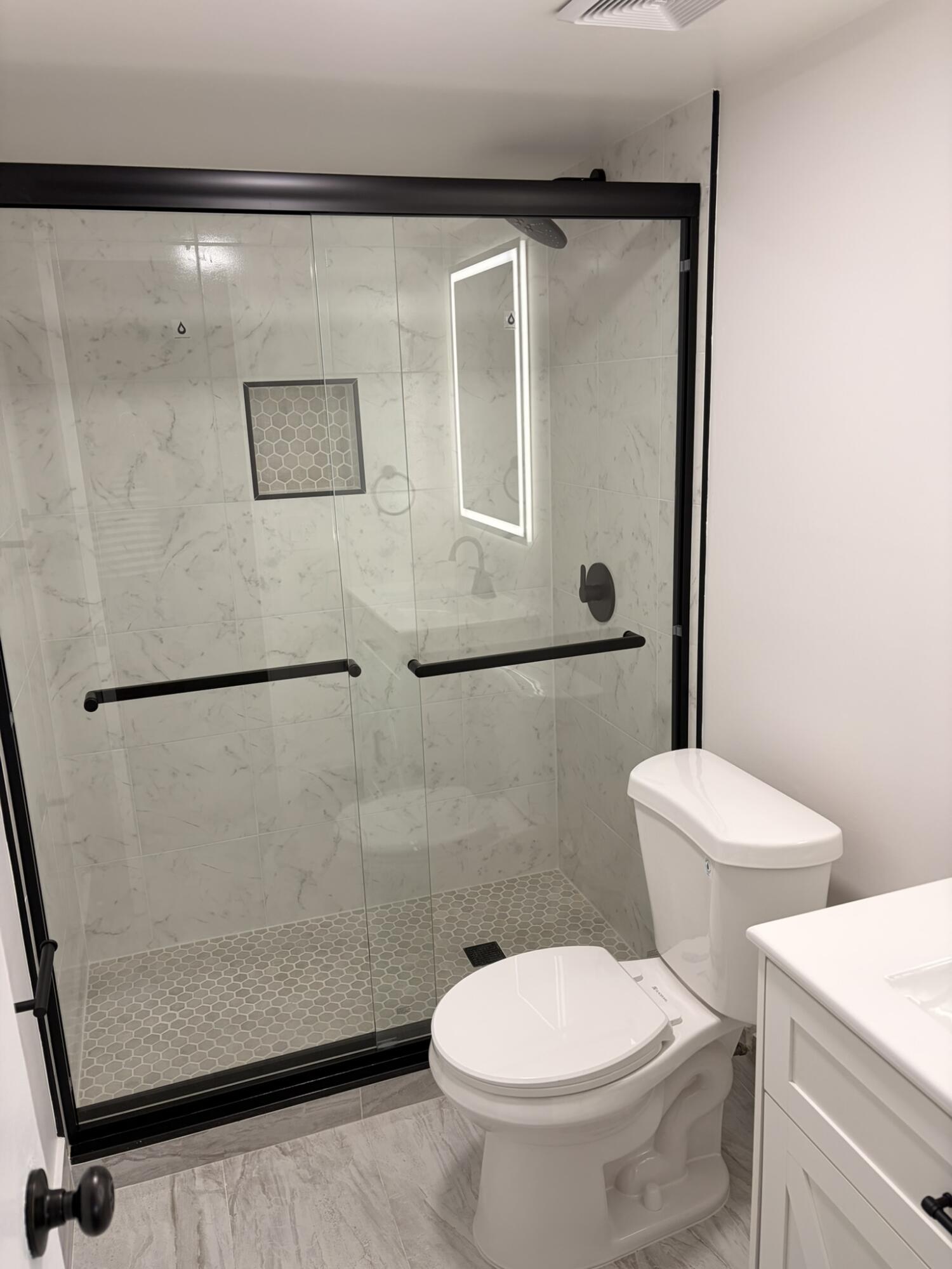 9374 Southwest 3rd Street, Unit 714 Boca Raton, FL 33428 - Photo 13 of 21 a white toilet sitting next to a bathroom sink