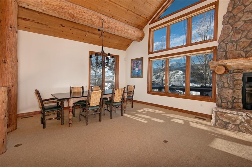 731 Pioneer Creek Road Silverthorne, CO 80498 - Photo 12 of 32 a dining room with furniture a floor to ceiling window and a fireplace