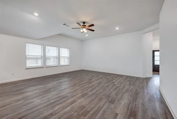 a kitchen with stainless steel appliances granite countertop a refrigerator a sink dishwasher a stove and white countertops with wooden floor