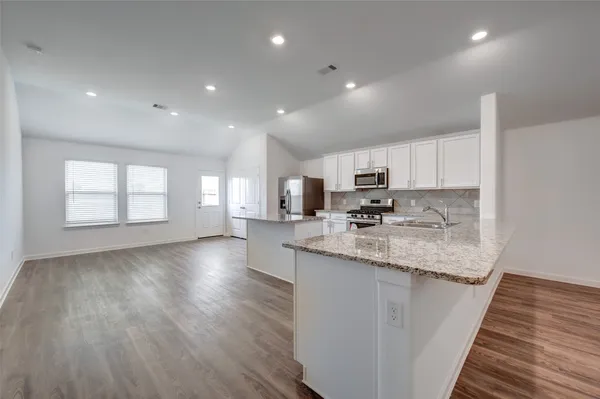 a kitchen with a sink and wooden floor