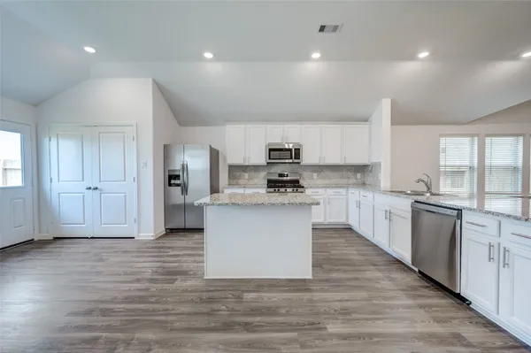 a view of kitchen view wooden floor stainless steel appliances and cabinets