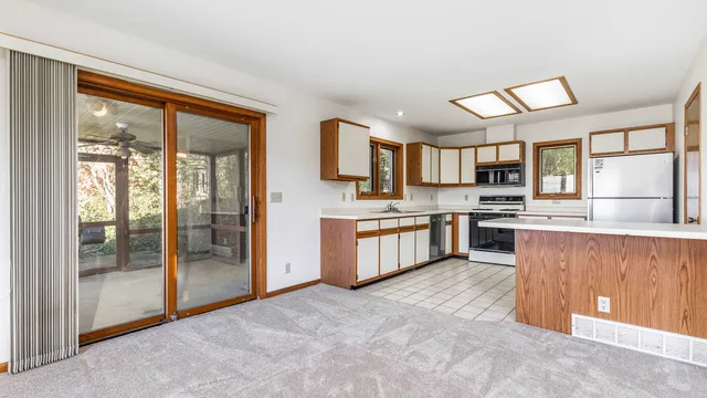 a large kitchen with a large window and stainless steel appliances