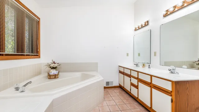 a bathroom with a tub sink and mirror