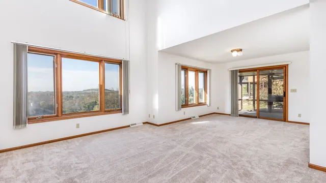 an empty room with windows and view of wooden floor