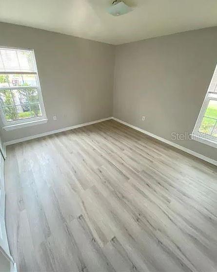 5455 Vineland Road, Unit 3108 Orlando, FL 32811 - Photo 15 of 17 an empty room with wooden floor and windows
