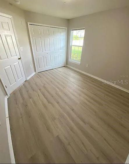 5455 Vineland Road, Unit 3108 Orlando, FL 32811 - Photo 16 of 17 an empty room with wooden floor and windows