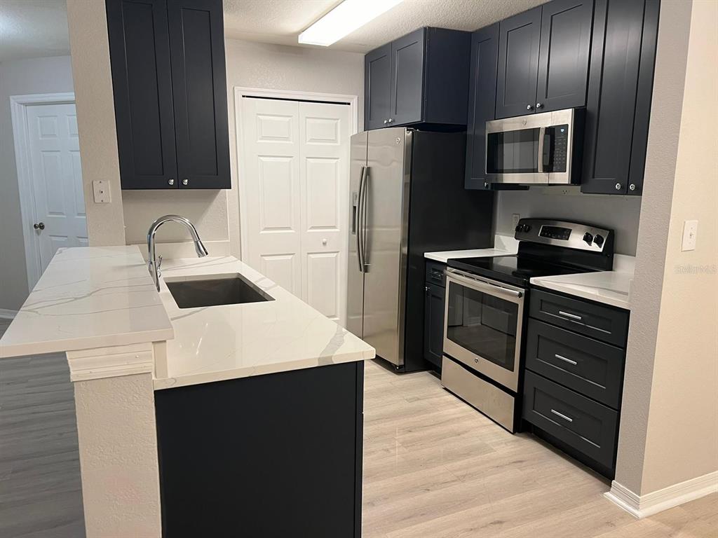 5455 Vineland Road, Unit 3108 Orlando, FL 32811 - Photo 4 of 17 a kitchen with a refrigerator sink and stove