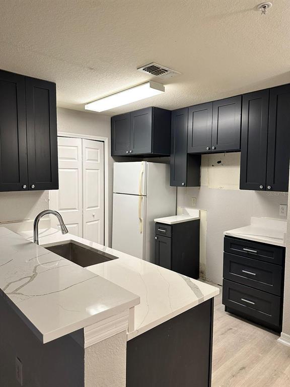 5455 Vineland Road, Unit 3108 Orlando, FL 32811 - Photo 6 of 17 a kitchen with kitchen island a sink stainless steel appliances and cabinets