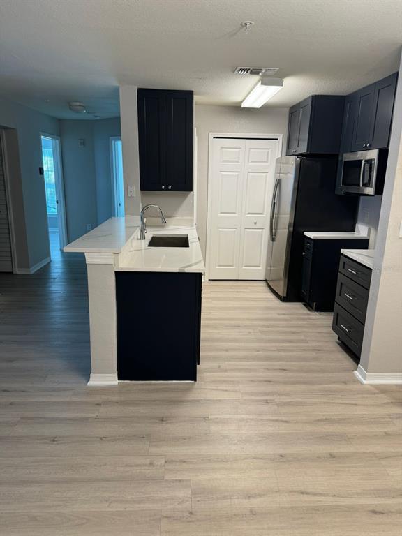 5455 Vineland Road, Unit 3108 Orlando, FL 32811 - Photo 7 of 17 a kitchen view with wooden floor and electronic appliances