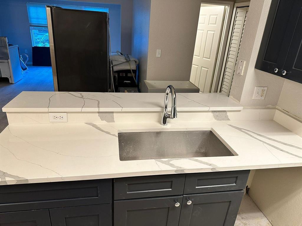 5455 Vineland Road, Unit 3108 Orlando, FL 32811 - Photo 9 of 17 a kitchen with a sink and a refrigerator