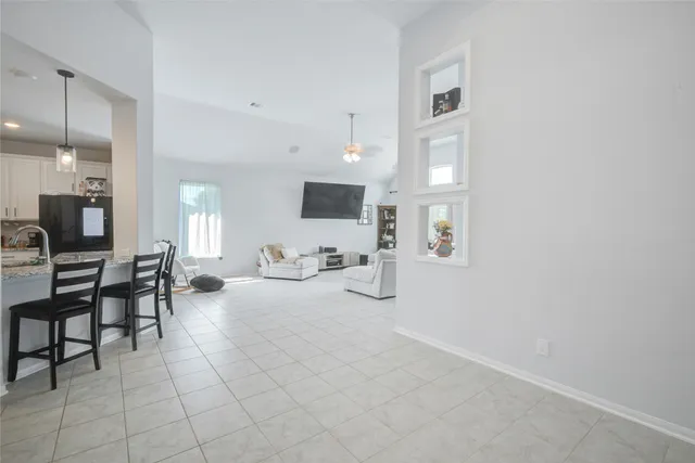 a living room with furniture a flat screen tv and kitchen view