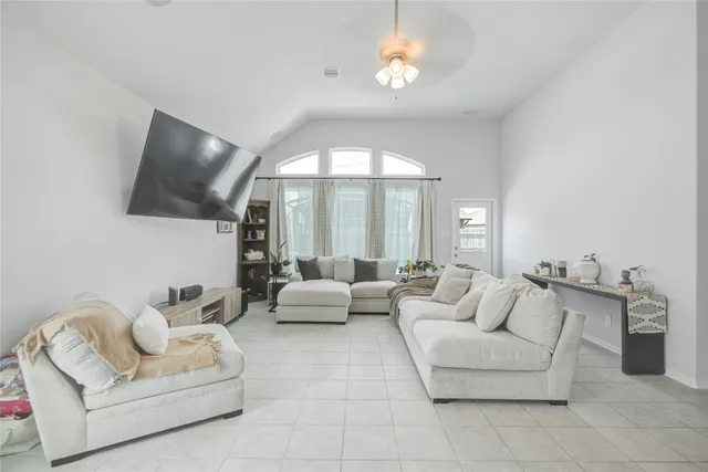 a living room with furniture chandelier and a flat screen tv