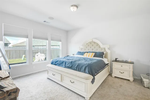 a spacious bedroom with a bed and a large window