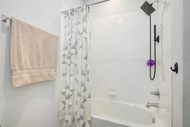 a bathroom with a shower curtain and a bathtub