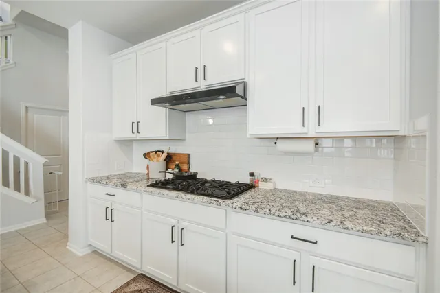 a kitchen with white cabinets and a sink
