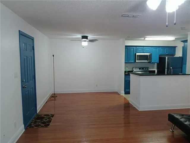 a kitchen with granite countertop a refrigerator and a stove top oven