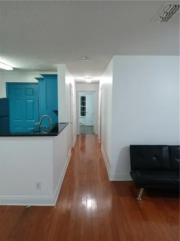 a view of a hallway with wooden floor and a couch