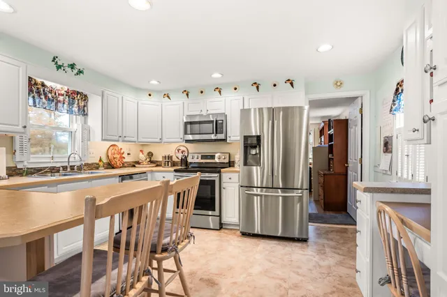 a kitchen with stainless steel appliances granite countertop a refrigerator and a stove top oven