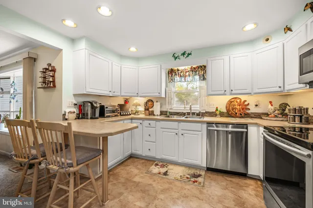 a kitchen with a sink window and cabinets
