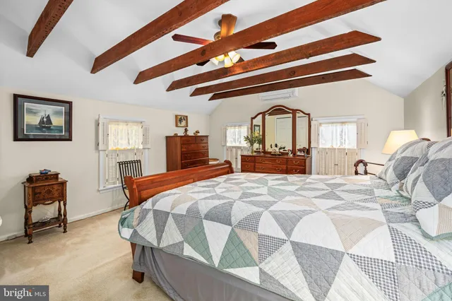 a spacious bedroom with a bed a dresser and chair