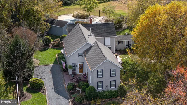 a aerial view of a house with a yard and large trees