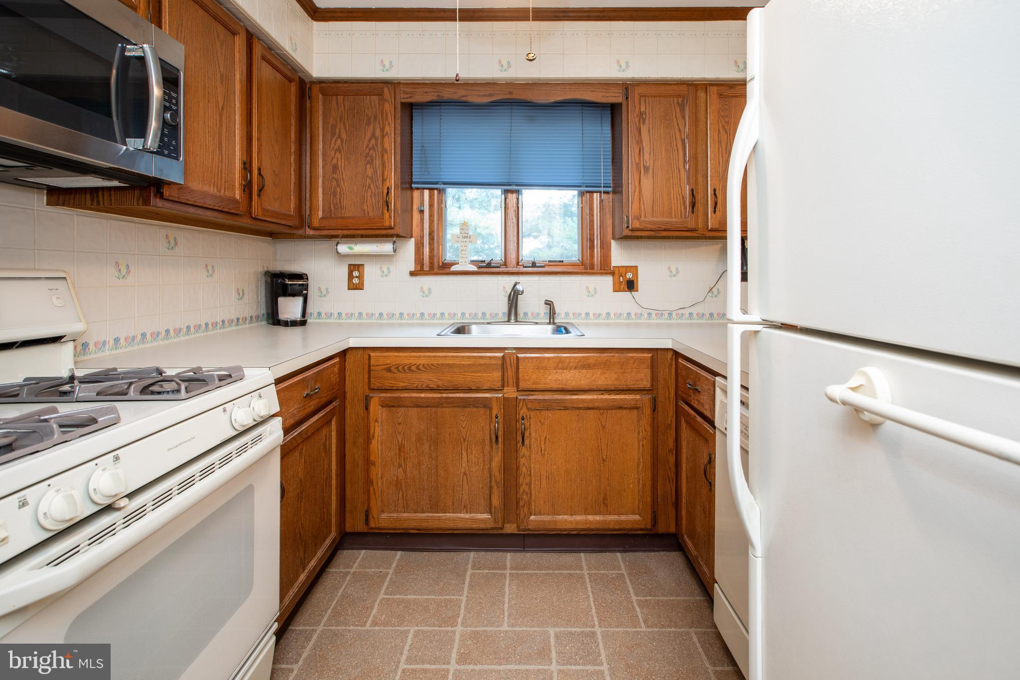 34 Kelly Court Hamilton, NJ 08690 - Photo 12 of 31 a kitchen with a sink a stove top oven and cabinetry