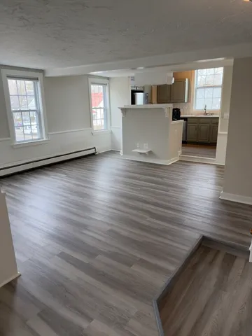 a view of living room and kitchen with wooden floor