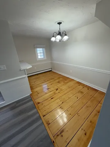a view of a room with wooden floor and ceiling fan