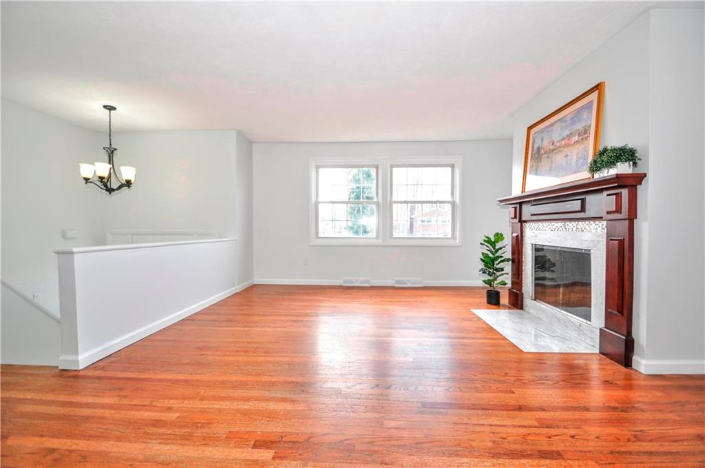 1313 Star Ridge Drive Pittsburgh, PA 15241 - Photo 6 of 36 a view of empty room with wooden floor fireplace and windows