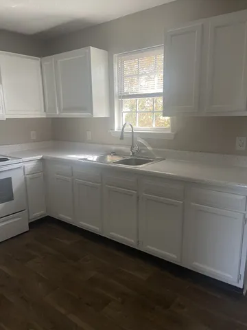 a kitchen with stainless steel appliances granite countertop a sink a window and a granite counter tops