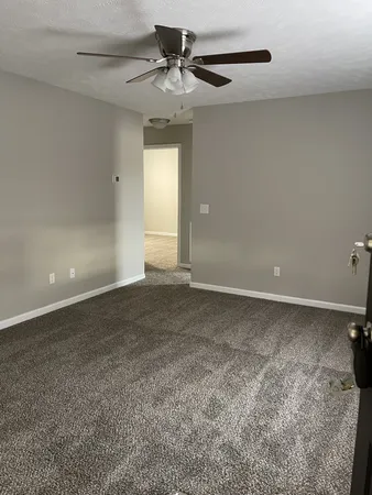 a view of a livingroom with a ceiling fan and window