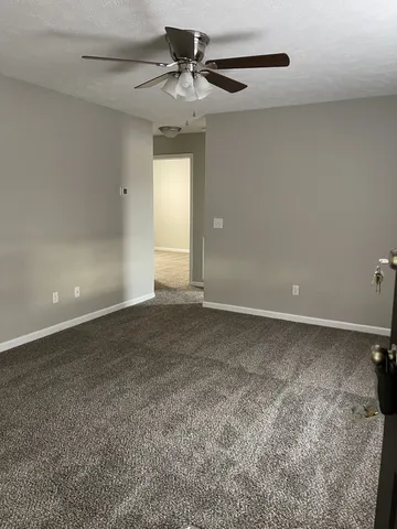 a view of a livingroom with a ceiling fan and window