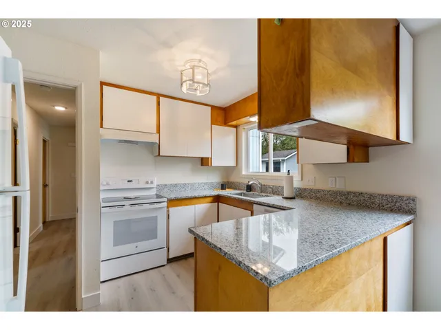 a kitchen with stainless steel appliances granite countertop a sink stove and cabinets