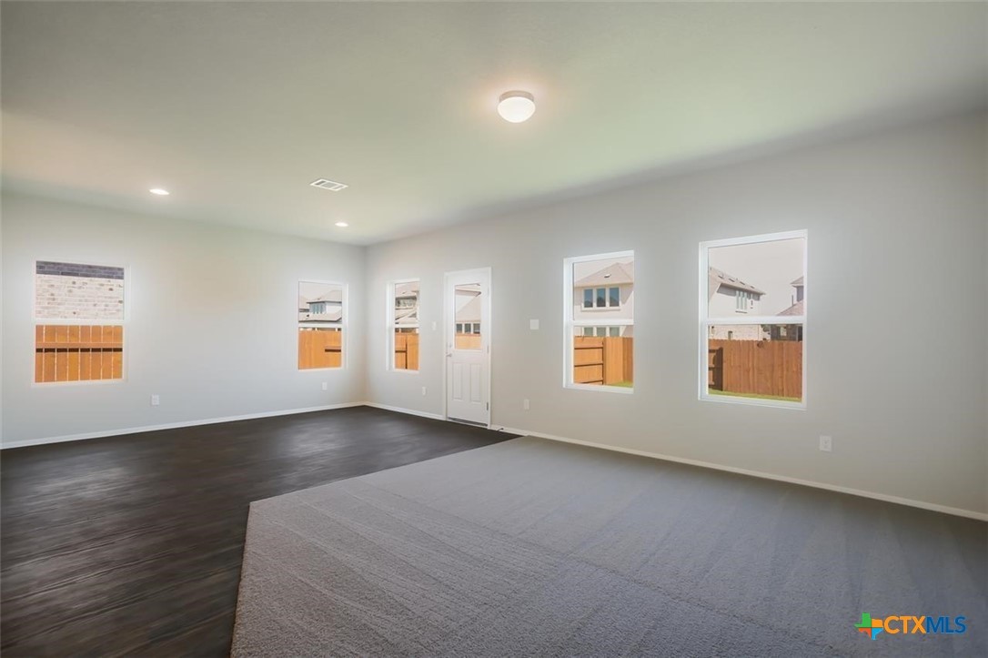 2428 Ambling Trail Georgetown, TX 78628 - Photo 12 of 33 a view of an empty room with a window and wooden floor