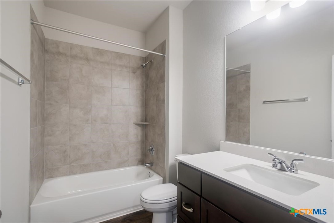 2428 Ambling Trail Georgetown, TX 78628 - Photo 20 of 33 a bathroom with a granite countertop bathtub shower sink vanity mirror and toilet