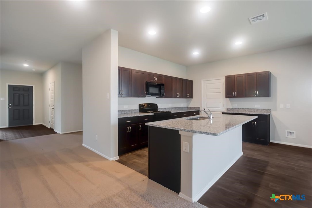 2428 Ambling Trail Georgetown, TX 78628 - Photo 4 of 33 a kitchen with a sink a counter top space stainless steel appliances and cabinets